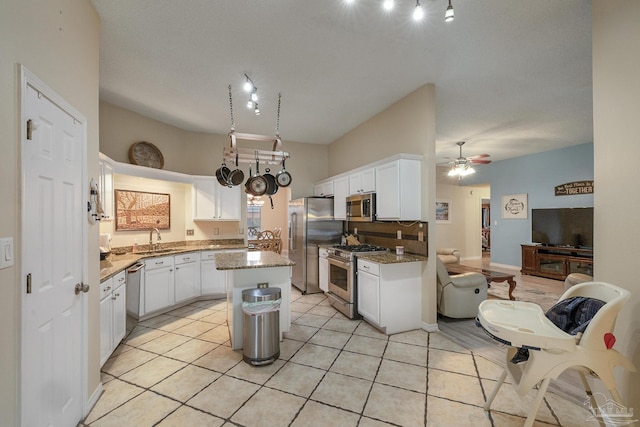 kitchen featuring appliances with stainless steel finishes, sink, white cabinetry, and a center island