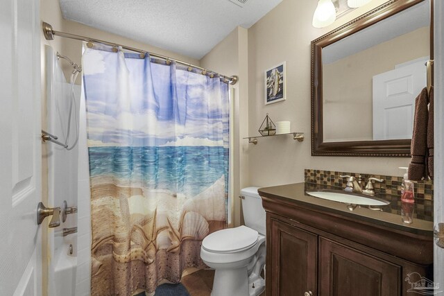 bathroom with vanity, toilet, and a textured ceiling