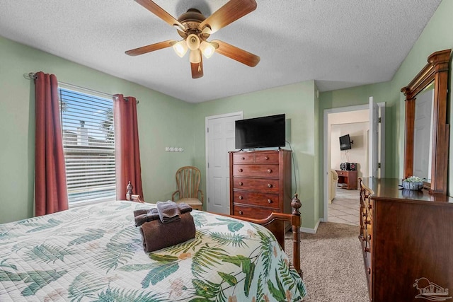 bedroom featuring light carpet, a textured ceiling, and ceiling fan