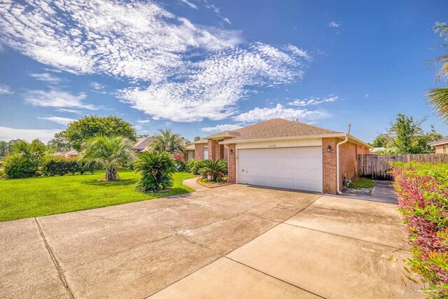 ranch-style home featuring a garage and a front lawn