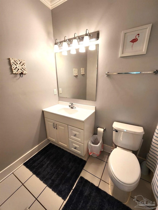 bathroom with tile patterned flooring, vanity, ornamental molding, and toilet