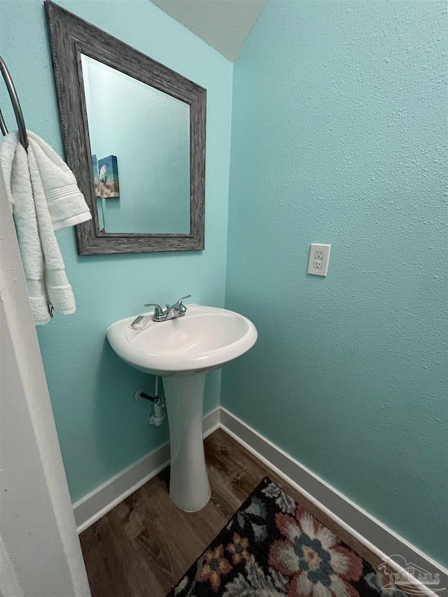 bathroom with a sink, baseboards, and wood finished floors