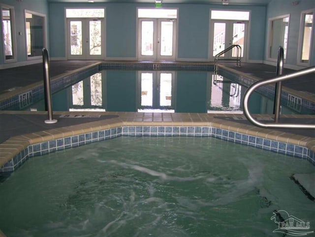 view of swimming pool featuring a hot tub and french doors