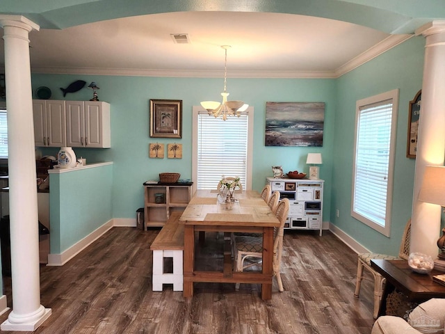 dining room featuring decorative columns, crown molding, dark wood-type flooring, and a chandelier