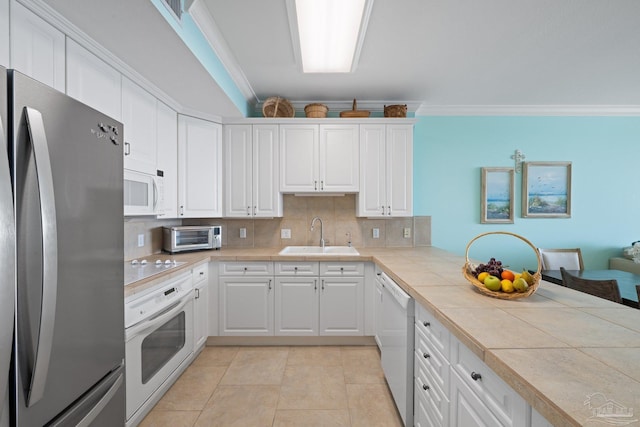 4050 Indigo Dr Unit 102, Pensacola, FL 32507 - kitchen featuring white appliances, a sink, ornamental molding, tile counters, and tasteful backsplash