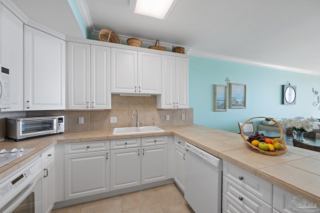 4050 Indigo Dr Unit 102, Pensacola, FL 32507 - kitchen with white dishwasher, a sink, oven, ornamental molding, and white cabinetry