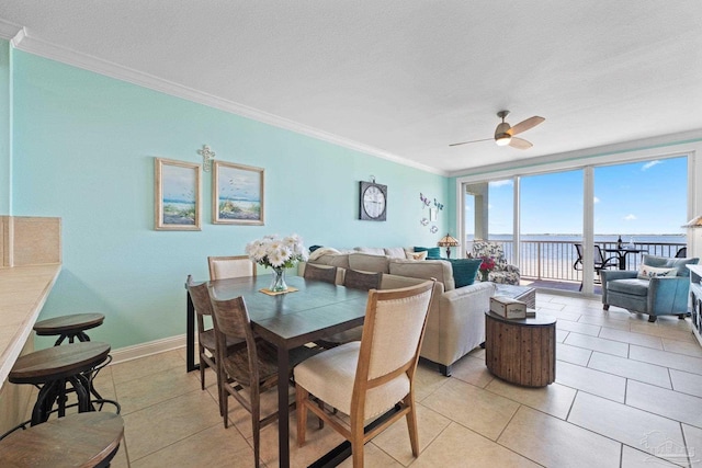 4050 Indigo Dr Unit 102, Pensacola, FL 32507 - dining area featuring crown molding, a water view, ceiling fan, light tile patterned flooring, and baseboards