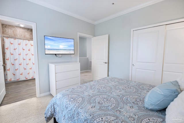 bedroom with a closet, ornamental molding, and light carpet