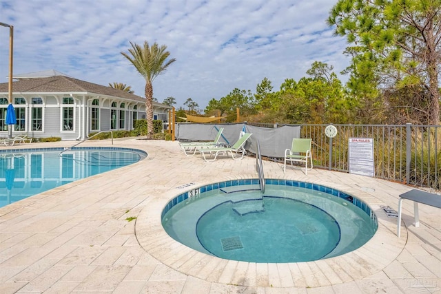 view of swimming pool with a hot tub and a patio area