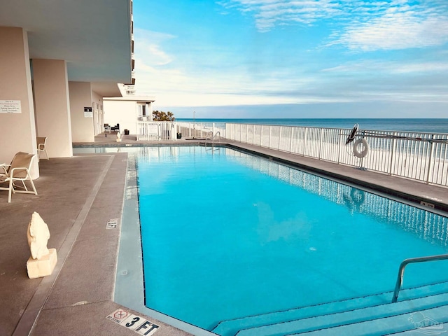 pool with a water view and a patio