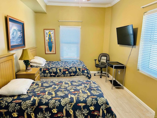 bedroom featuring baseboards, wood finished floors, and crown molding