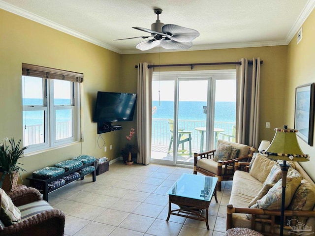 living area with light tile patterned floors, plenty of natural light, crown molding, and a ceiling fan