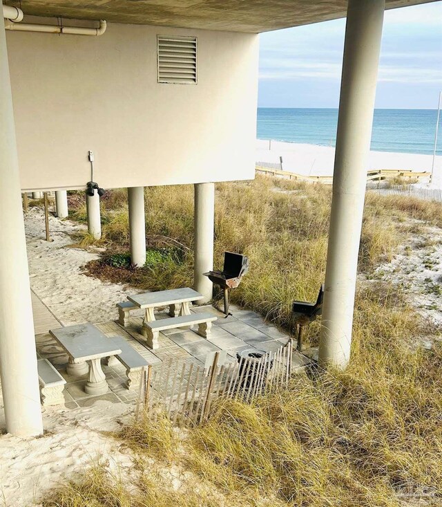 view of patio featuring a water view, visible vents, and a view of the beach