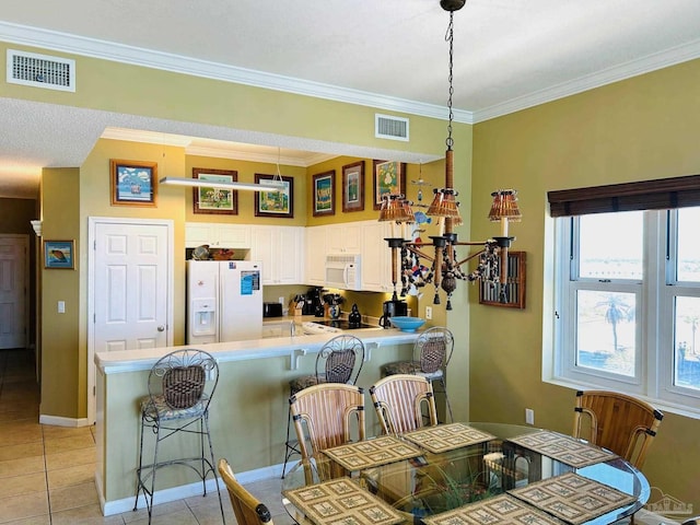 dining area featuring light tile patterned floors, visible vents, and crown molding