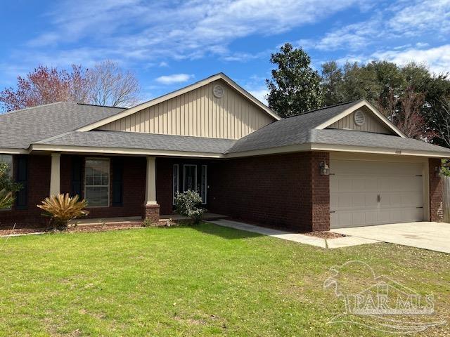 ranch-style home featuring an attached garage, a front lawn, concrete driveway, and brick siding