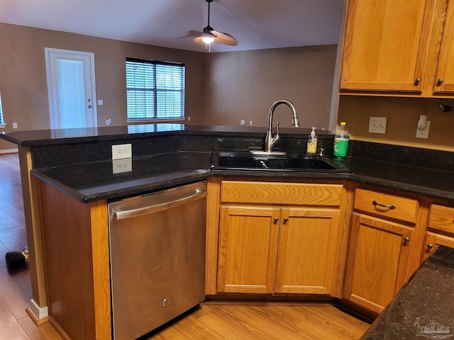 kitchen featuring dark stone counters, ceiling fan, sink, and stainless steel dishwasher