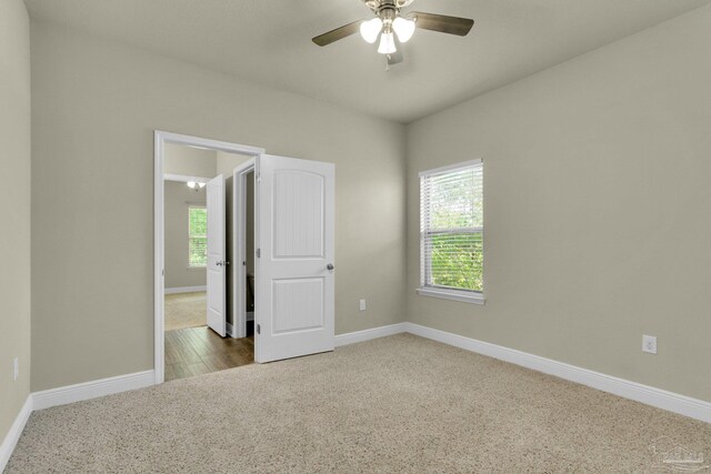 carpeted spare room featuring ceiling fan