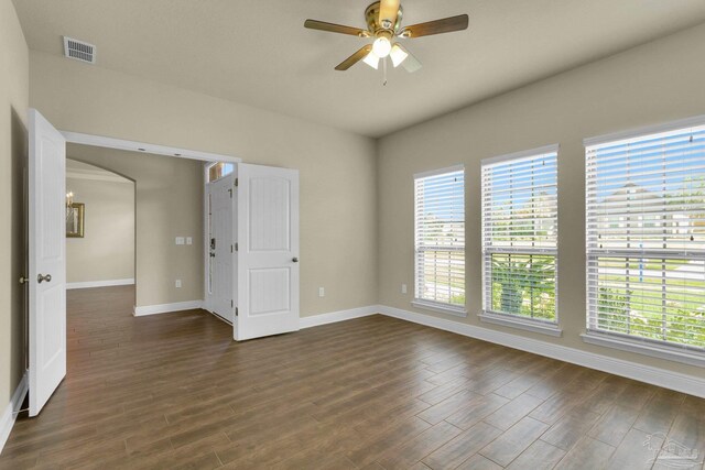 unfurnished room featuring a wealth of natural light, wood-type flooring, and ceiling fan