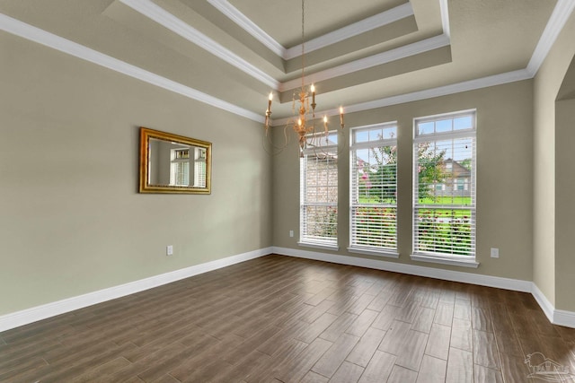 spare room with crown molding, a tray ceiling, dark wood-style flooring, and baseboards