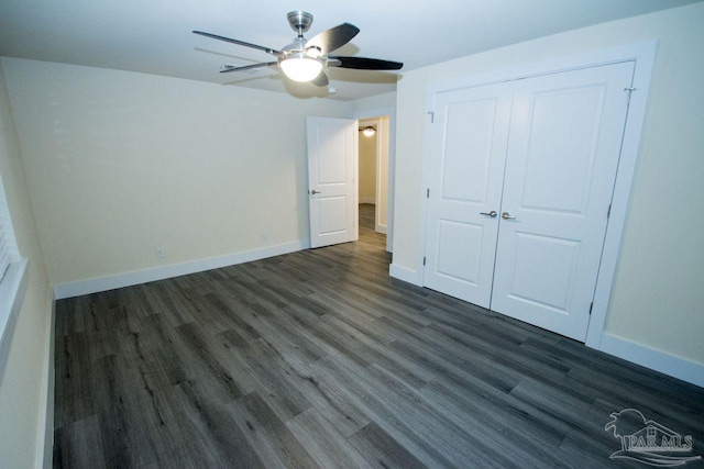 unfurnished bedroom with dark wood-type flooring, ceiling fan, and a closet