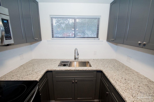 kitchen featuring tasteful backsplash, sink, black electric range, and light stone countertops