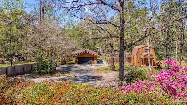 1221 Tecumseh Pl, Pensacola, FL 32514 - view of front of home with an outbuilding, a gambrel roof, a detached garage, and a view of trees