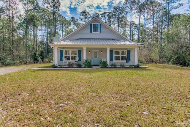 view of front facade featuring a front yard, covered porch, and metal roof