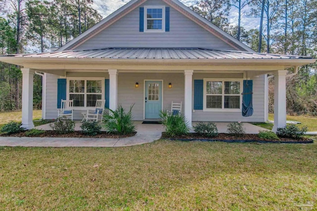 bungalow-style house featuring metal roof, a porch, and a front lawn