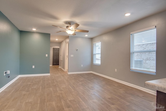 unfurnished room with ceiling fan and light wood-type flooring