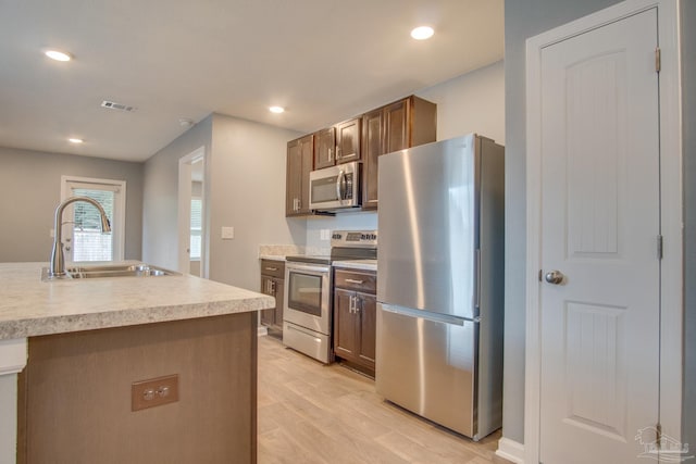 kitchen featuring sink, stainless steel appliances, and light wood-type flooring