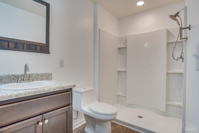 bathroom with vanity, toilet, wood-type flooring, and a shower