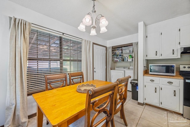 dining room with a textured ceiling, independent washer and dryer, a notable chandelier, and light tile patterned floors