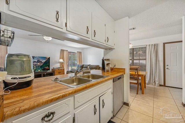 kitchen with light countertops, dishwasher, a sink, light tile patterned flooring, and white cabinetry