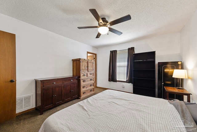 bedroom featuring a textured ceiling, carpet floors, visible vents, and a ceiling fan