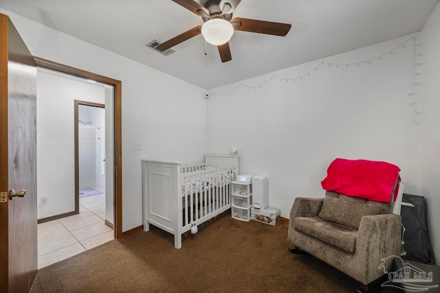 carpeted bedroom with tile patterned floors, a ceiling fan, visible vents, and baseboards