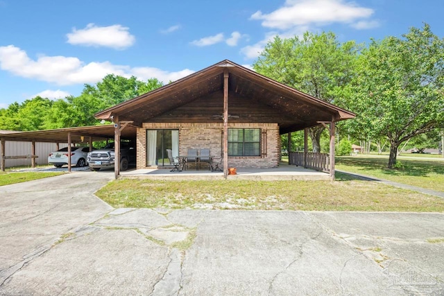 view of front of home with a carport, driveway, a front lawn, and brick siding