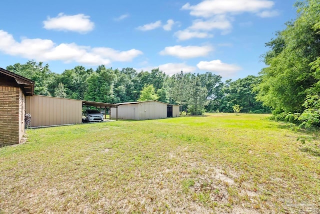 view of yard featuring an outdoor structure, a detached carport, and a pole building