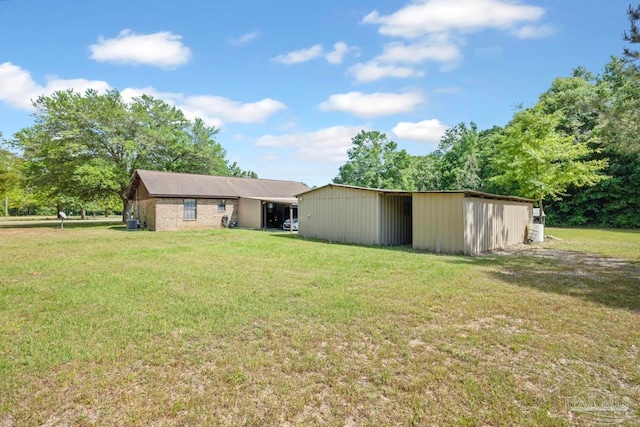 back of house with a yard and an outbuilding