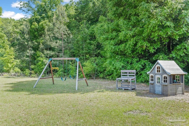 view of jungle gym with a lawn, an outbuilding, and a shed