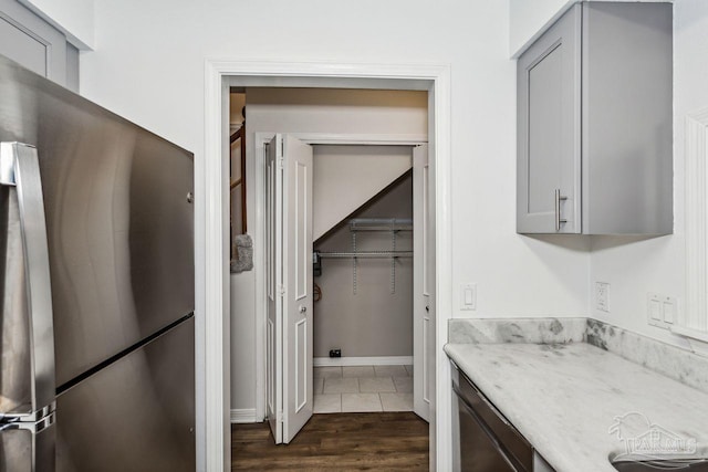 kitchen with dark wood-type flooring, stainless steel fridge, and gray cabinetry