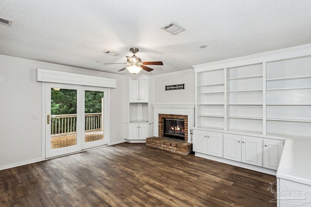 unfurnished living room with a fireplace, a textured ceiling, dark hardwood / wood-style flooring, ceiling fan, and ornamental molding