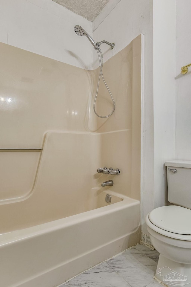 bathroom featuring tile patterned flooring, toilet, a textured ceiling, and shower / bathing tub combination