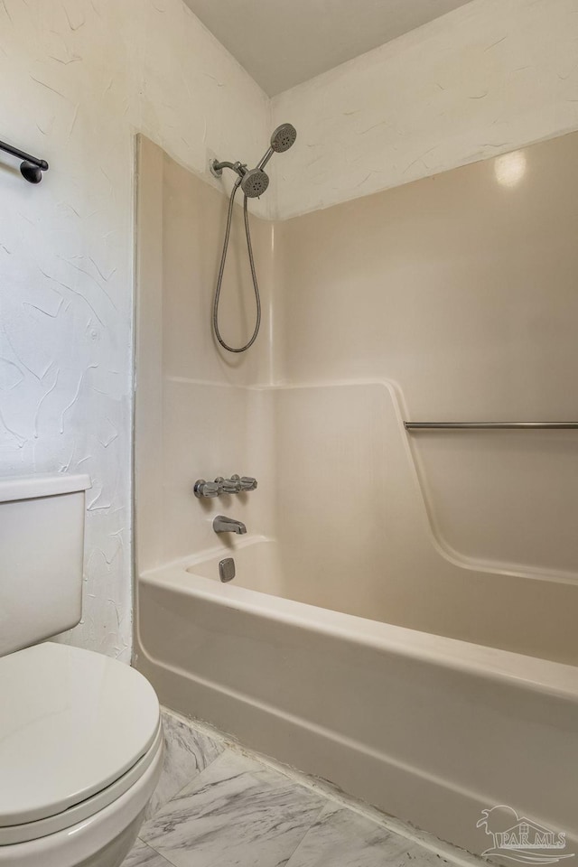 bathroom with toilet, washtub / shower combination, and tile patterned floors