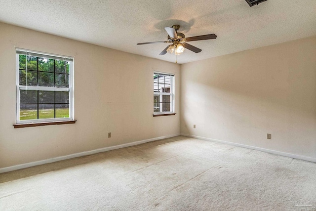 spare room with carpet floors, plenty of natural light, and ceiling fan