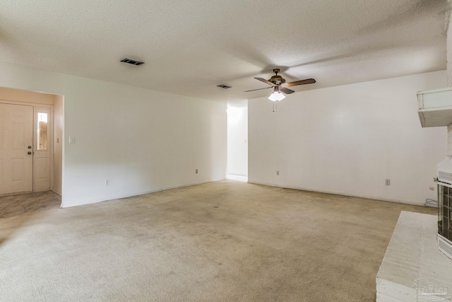 unfurnished room featuring ceiling fan, a textured ceiling, and light carpet