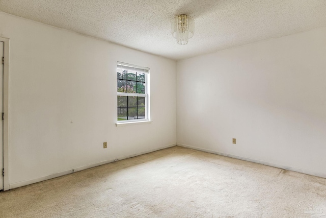 empty room with a textured ceiling and carpet flooring