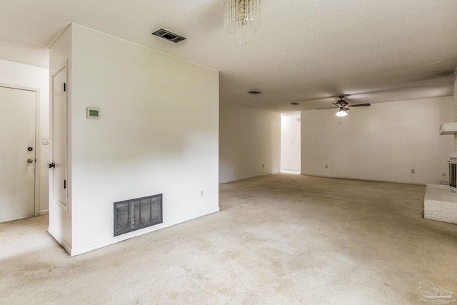 empty room featuring light carpet, a textured ceiling, and ceiling fan with notable chandelier