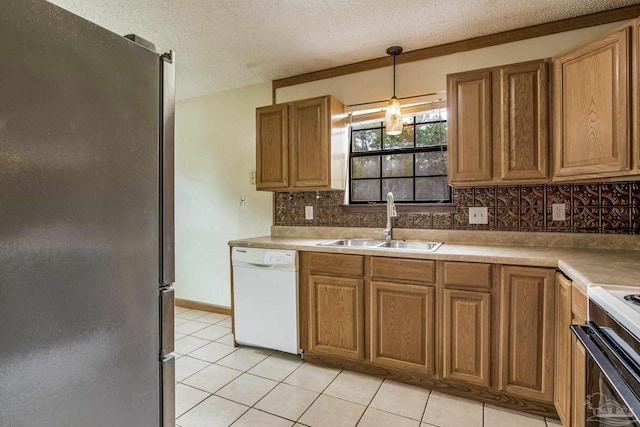 kitchen featuring light tile patterned flooring, sink, dishwasher, pendant lighting, and refrigerator