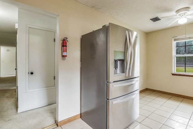 kitchen with ceiling fan, stainless steel fridge with ice dispenser, a textured ceiling, and light tile patterned floors