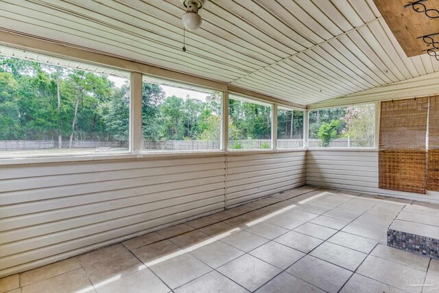 unfurnished sunroom featuring wood ceiling and lofted ceiling